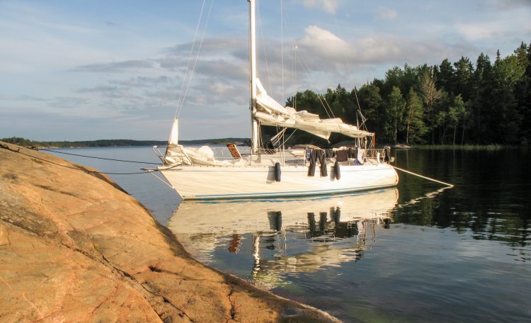 Segelbåt ligger förtöjd vid klippa